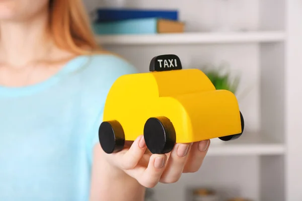 女子手持黄色玩具的士驾驶室, 室内 — 图库照片