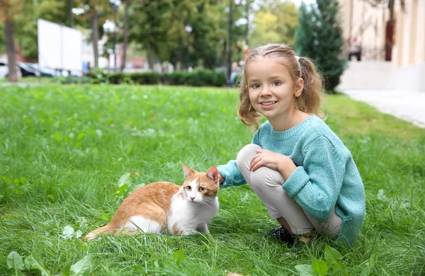 Sevimli küçük kız açık havada kedi ile — Stok fotoğraf
