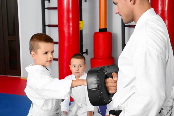 Männlicher Karatelehrer trainiert kleinen Jungen im Dojo — Stockfoto