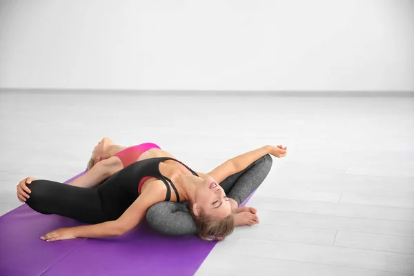 Twee jonge vrouwen die het beoefenen van yoga op lichte kamer — Stockfoto