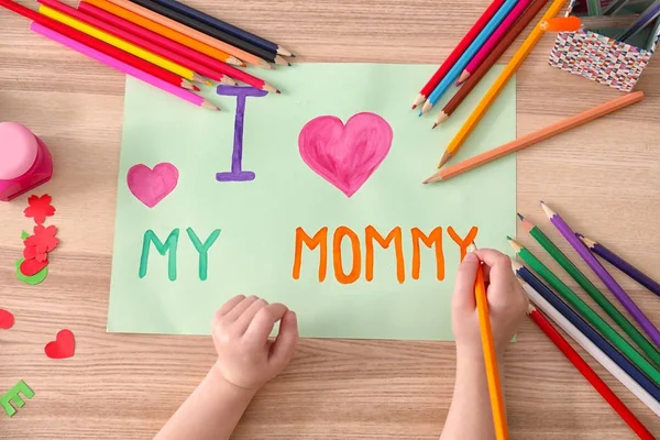 Mała dziewczynka rysunek z życzeniami na dzień matki w tabeli — Zdjęcie stockowe