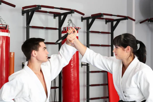Młody mężczyzna i kobieta uprawiania sztuk walki w dojo — Zdjęcie stockowe