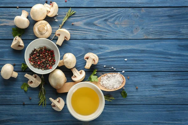 Fresh champignon mushrooms with spices on wooden background — Stock Photo, Image