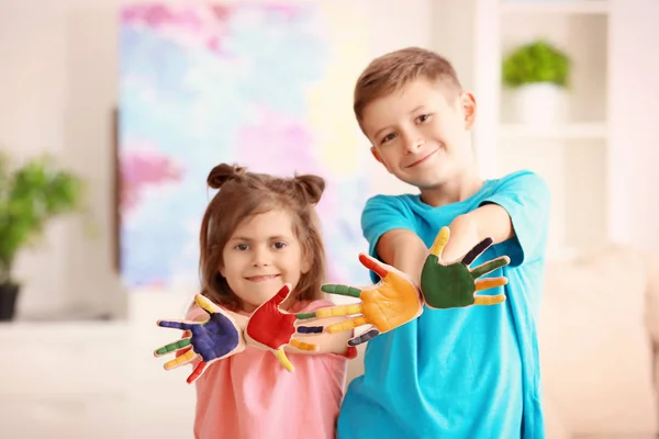 Crianças pequenas com as mãos pintadas em casa — Fotografia de Stock