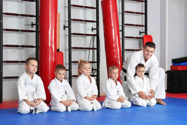 Instrutor de karatê masculino com crianças pequenas no dojo — Fotografia de Stock