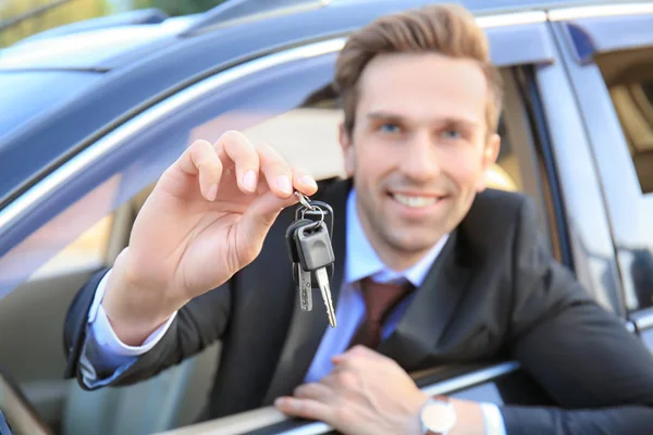 Young businessman with keys in car — Stock Photo, Image