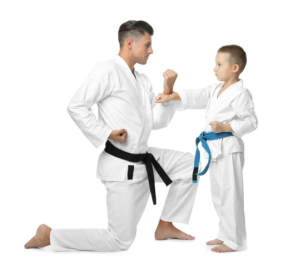 Kleines Kind mit Instruktor, der Karate auf weißem Hintergrund übt — Stockfoto