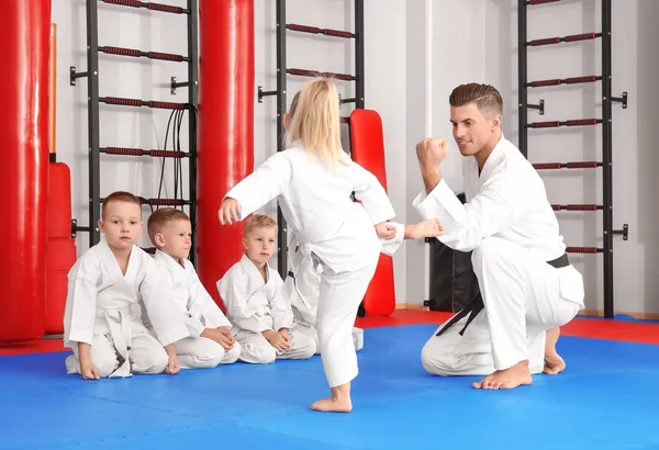 Instrutor de karatê masculino treinando crianças no dojo — Fotografia de Stock