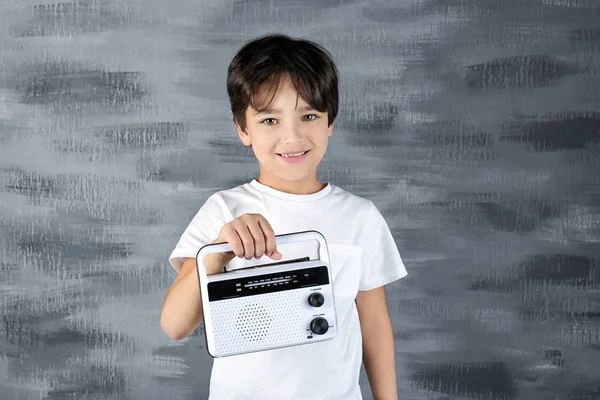 Mały chłopiec z radia na szarym tle — Zdjęcie stockowe