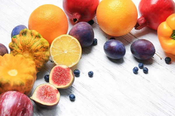 Склад різних фруктів і овочів на білому дерев'яному фоні — стокове фото
