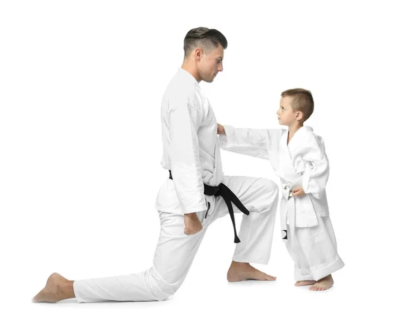 Kleiner Junge mit Instruktor übt Karate auf weißem Hintergrund — Stockfoto