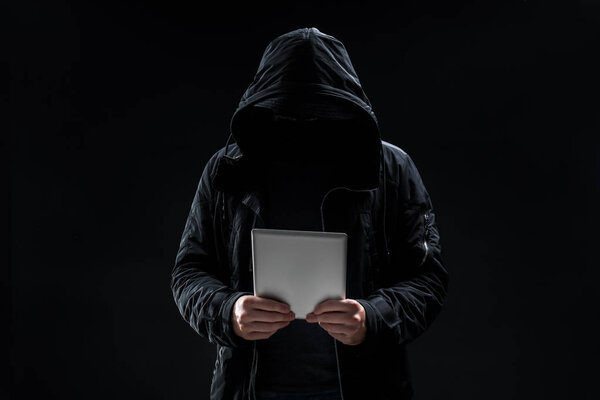 Hacker with tablet on dark background