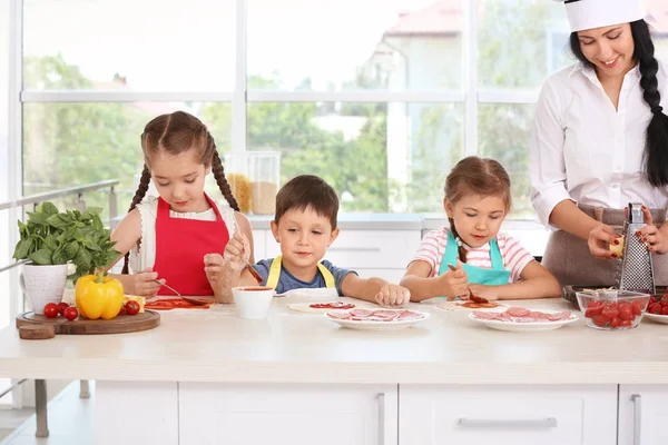 Gruppo di bambini e insegnante in cucina durante le lezioni di cucina — Foto Stock