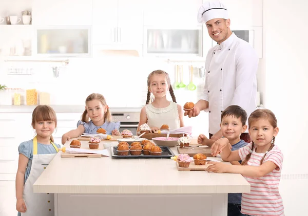 Group of children and teacher in kitchen during cooking classes Stock Photo