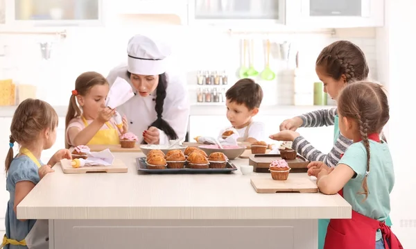 Group of children and teacher in kitchen during cooking classes Stock Image