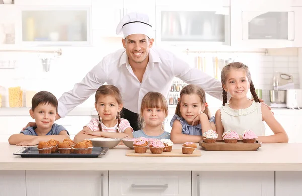 Group of children and teacher in kitchen during cooking classes Royalty Free Stock Photos