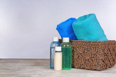 Temiz havlu ve açık renkli karşı masada kozmetik ile hasır sepet