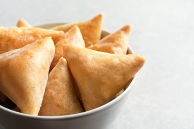 Işık arka plan üzerinde lezzetli samosas ile kase