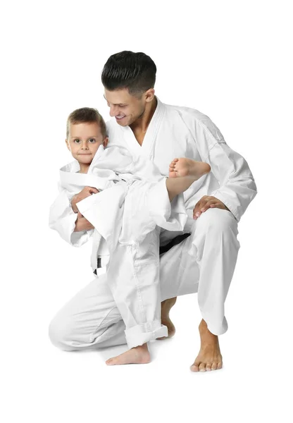 Niño pequeño con instructor practicando karate sobre fondo blanco — Foto de Stock