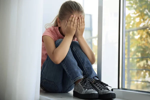 小伤心的女孩在家里哭。虐待儿童概念 — 图库照片