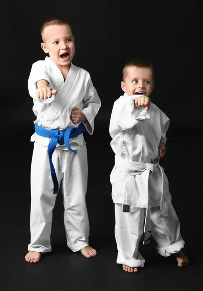 Kleine Kinder üben Karate auf dunklem Hintergrund — Stockfoto