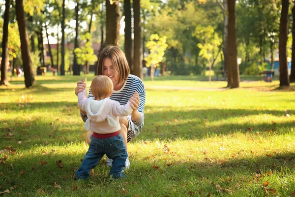 Мама с очаровательной маленькой девочкой играют вместе в осеннем парке — стоковое фото