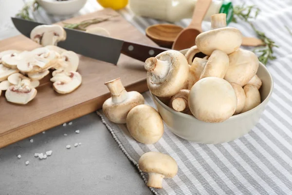 Bowl and fresh champignon mushrooms on table — Stock Photo, Image