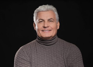 Siyah arka plan üzerine rahat kıyafetler içinde üst düzey yakışıklı