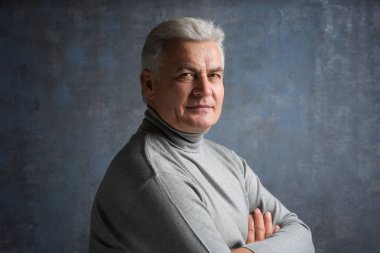 Gri arka plan üzerinde rahat kıyafetler içinde üst düzey yakışıklı