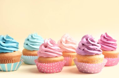 Delicious cupcakes on color background clipart