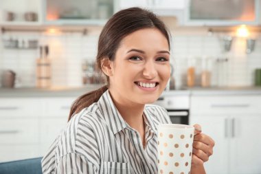 Gülümseyen kadın kapalı çay içme çizgili bluz