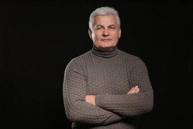 Siyah arka plan üzerine rahat kıyafetler içinde üst düzey yakışıklı