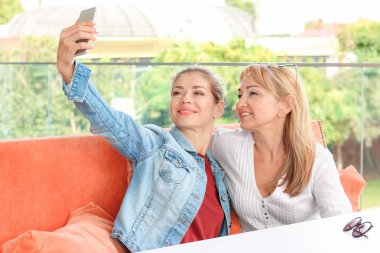 Olgun kadın ve kızı selfie kafede alarak