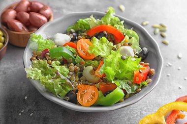 Gri zemin üzerine lezzetli sebze salatası ile kase