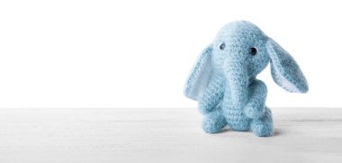 Beyaz arka plan karşı masada şirin örgü oyuncak fil