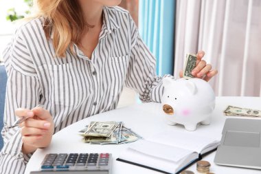 Genç Bayan piggy banka, closeup para koyarak
