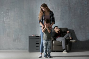 Babası arka plan üzerinde içme sırasında küçük oğlu rahatlatıcı kadın