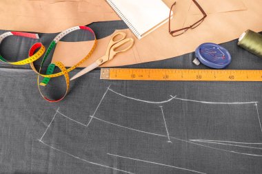 Gri kumaş ve dikiş aksesuarları masada, üstten görünüm