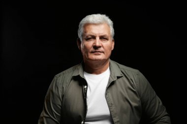 Siyah arka plan üzerine rahat kıyafetler içinde üst düzey yakışıklı