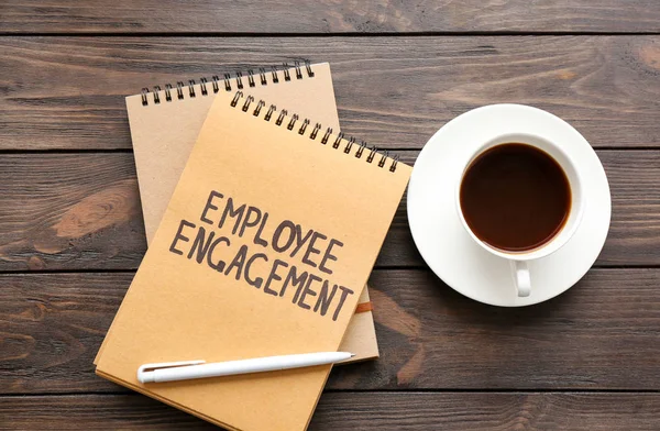 Bloc-notes avec texte ENGAGEMENT DES EMPLOYÉS et café sur la table — Photo