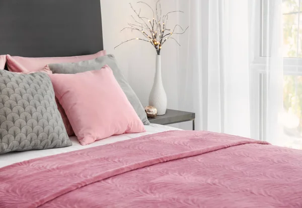 Bequemes Bett mit Kissen im Zimmer — Stockfoto