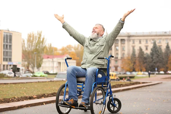 Старший чоловік в інвалідному візку на відкритому повітрі в осінній день — стокове фото