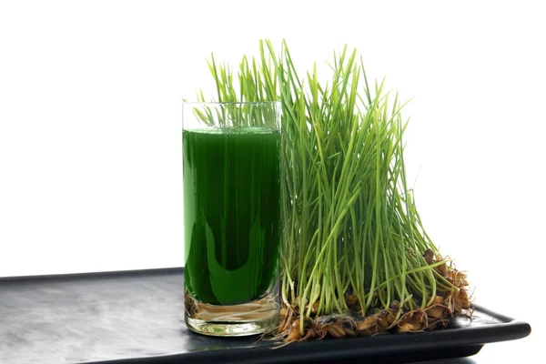 Tray with shot of healthy juice and sprouted wheat grass on white background — Stock Photo, Image