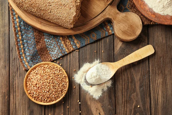 Harina de trigo sarraceno y granos crudos en utensilios de cocina — Foto de Stock