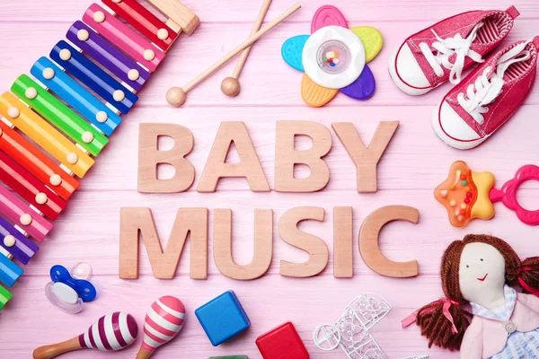 Texto BABY MUSIC e brinquedos sobre fundo de madeira — Fotografia de Stock