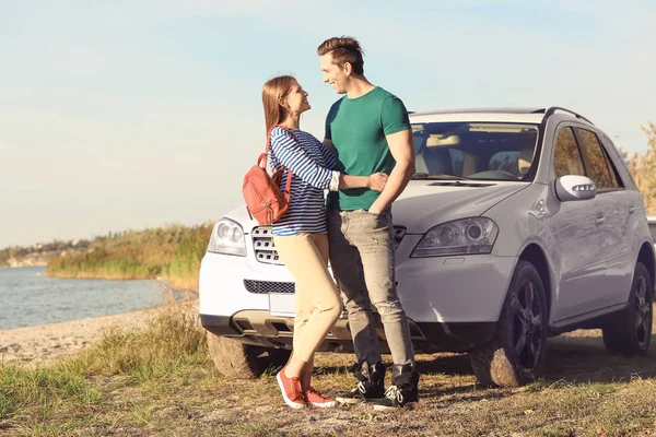 Bella giovane coppia in piedi vicino auto all'aperto — Foto Stock