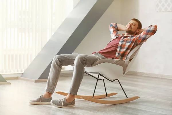 Handsome man relaxing in rocking-chair at home — Stock Photo, Image