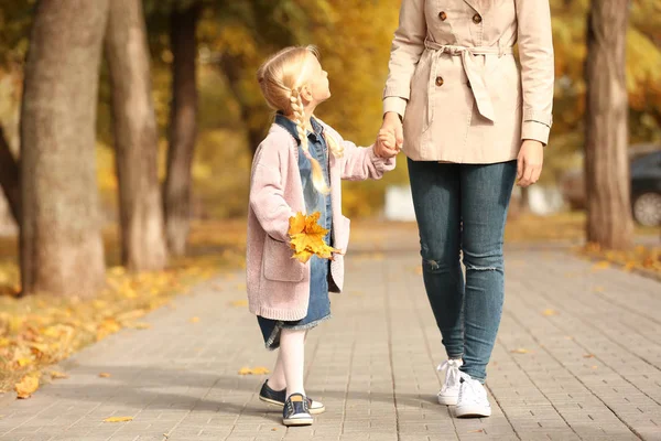 Liten flicka och mor vandrar tillsammans i parken — Stockfoto