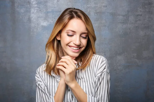 Femme souriante en chemisier rayé sur fond gris — Photo