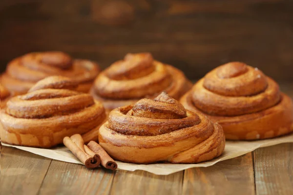 Sweet cinnamon rolls on wooden table — Stock Photo, Image